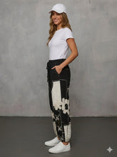 Load image into Gallery viewer, Side view of black patchwork joggers with cream floral details
